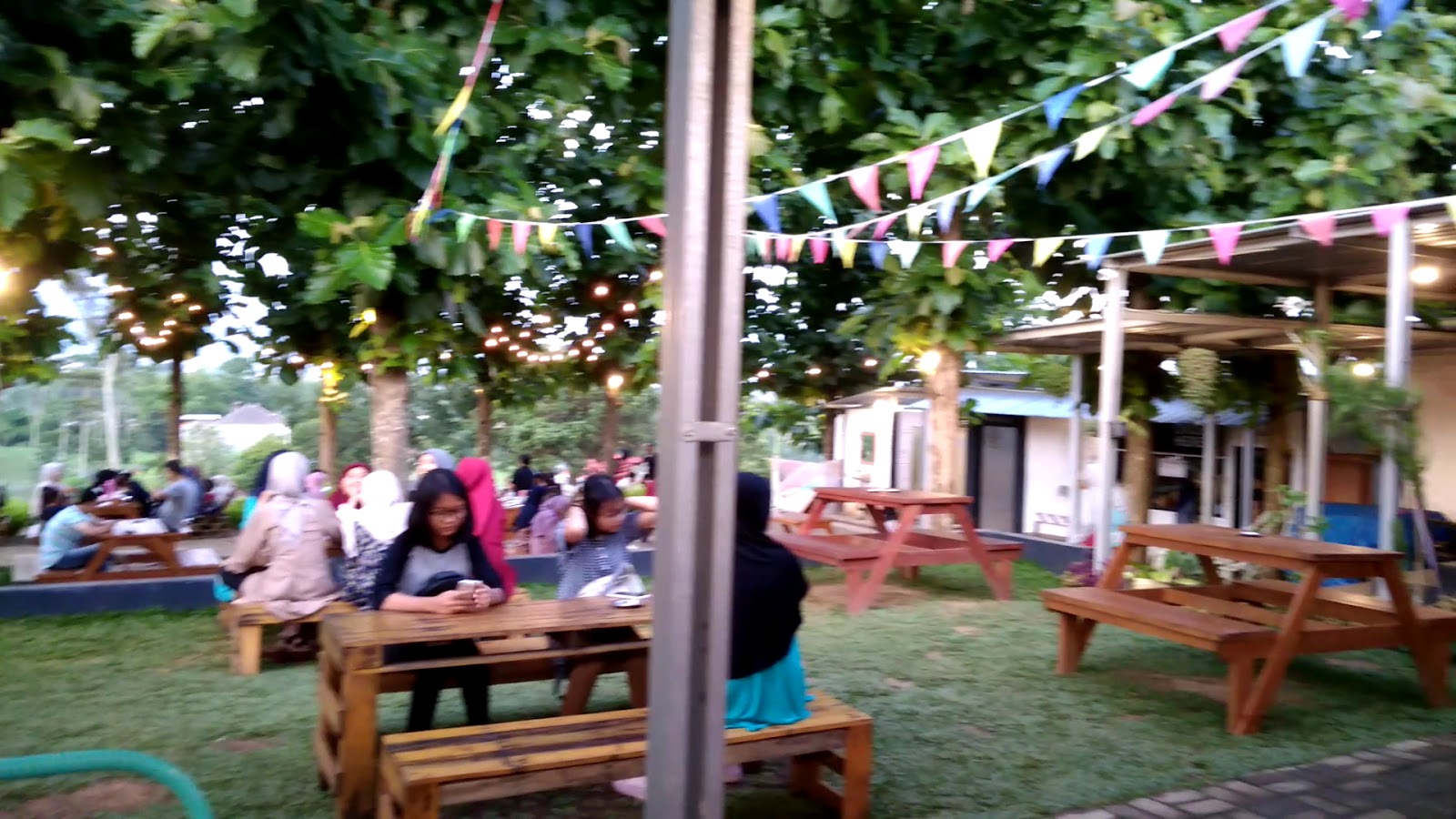 Area indoor CONWAY dengan kursi dan meja kayu, pencahayaan hangat