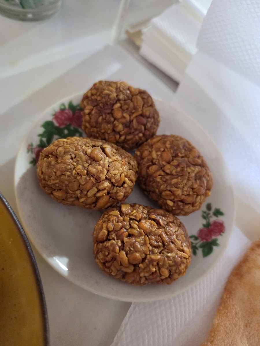 Empat butir mendol goreng berwarna cokelat keemasan di atas piring keramik bermotif bunga.